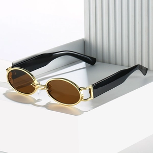 Retro oval sunglasses with gold metal frame and dark brown lenses on white geometric stand
