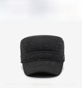 Detail of grey winter flat top military cap showing thick wool texture and metal button