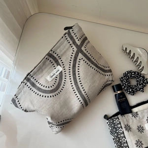Detail of printed cotton linen makeup bag with geometric pattern and top zip handle