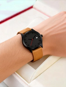 Gros plan sur une montre d'affaires noire avec bracelet en cuir marron et dateur