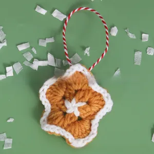 Detail of handmade crochet star ornament with woven texture and red-white spiral lanyard