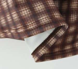 Vista macro de la textura de la tela de cuadros marrón y las costuras del conjunto sexy
