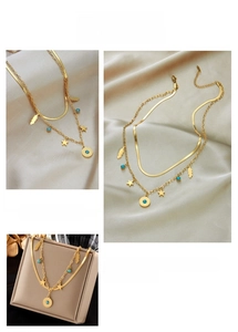 Detail of layered gold titanium necklace with star, feather and turquoise pendants