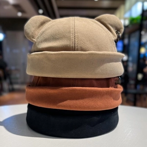 Detailed view of brimless dock hats with bear ears and metal ring in three colors