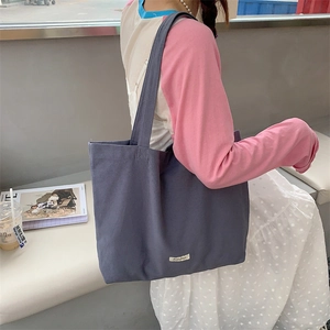 Minimalist dark grey canvas tote bag with ergonomic shoulder strap for daily commuting