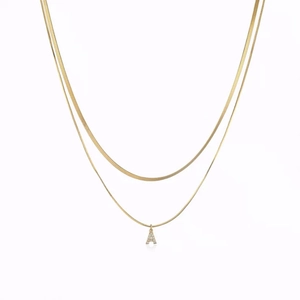 Double-layer gold snake chain necklace featuring a sparkling diamond-set letter A pendant