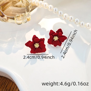 Macro shot of burgundy flower earrings with gold stamens showing size and weight details