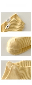 Détails macro de chaussettes en coton jaune avec bords élastiques et étiquette tissée
