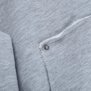 Détail d'un sweat à capuche gris doublé polaire avec bouton en métal et tissu chaud