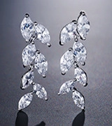 Detailed macro view of marquise-cut zircons set in a silver leaf-shaped earring design
