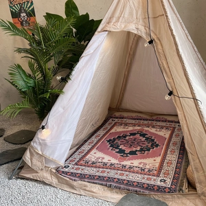 Detail of a bohemian geometric picnic blanket used inside a pyramid camping tent