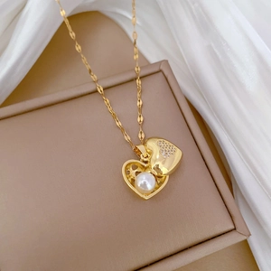 Close-up of golden heart locket necklace with white pearl and sparkling crystals