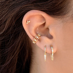 Detailed view of gold geometric triangle drop earrings and studs with zirconia