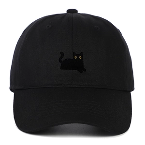 Gros plan de la broderie chat noir détaillée avec yeux jaunes sur casquette noire