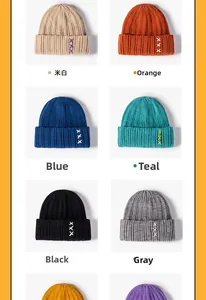Detail of multi-color knitted beanies with thick texture and triple X embroidery