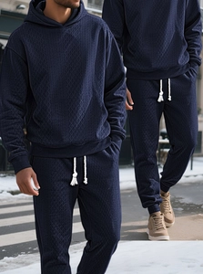 Detail of navy blue hooded tracksuit featuring geometric jacquard waffle knit texture
