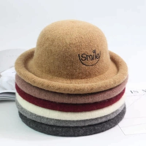 Close-up of stacked colorful wool felt hats with Smile embroidery detail for children