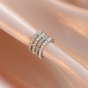 Multi-layer silver ear cuff with pearls and zircons on elegant satin background