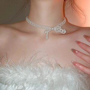 Gros plan du design de nœud papillon et texture de perles sur le collier élégant