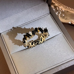 Elegant gold plated ring with black baguette stones and white diamonds in a jewelry box