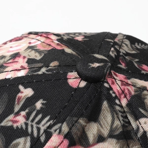 Detail of floral baseball cap crown showing fabric texture and neat top button