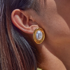 Vintage style gold stainless steel stud earrings with large oval pearl on female model