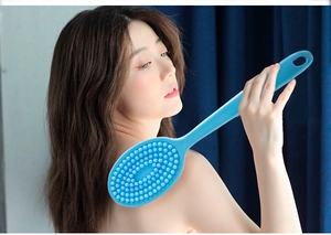 Blue silicone long-handle bath brush showing soft massage bristles on female model back