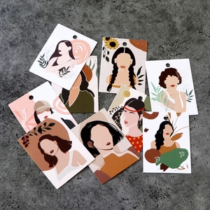 Detailed view of jewelry display cards with bohemian female illustrations on grey background