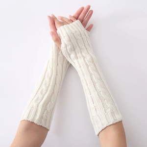Detail of white cable knit fingerless gloves showing long warm arm sleeve texture