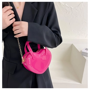 Hot pink heart-shaped patent leather crossbody bag with elegant gold chain strap detail