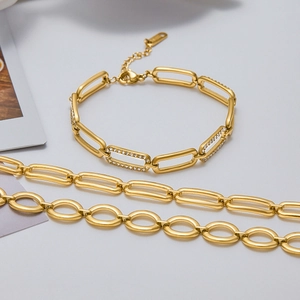 Macro detail of gold plated rectangular link chain and zircon inlaid bracelet for women