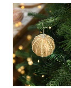 Detail of 8cm champagne gold Christmas ball with pearls on a festive tree branch