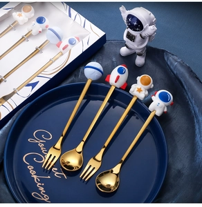 Detail of golden astronaut themed cutlery set including spoons and forks in a gift box