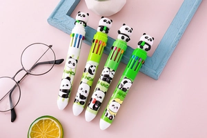 Detail of panda multi-color pens with decorative cute panda toppers on pink surface