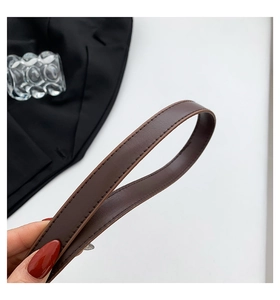 Detail of dark brown leather strap featuring premium texture and fine stitching