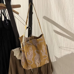 Sac bandoulière en coton jaune moutarde à imprimé léopard suspendu à un portant