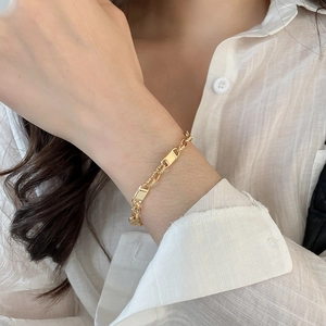 Detail of 18k gold plated hollow honeycomb cuff bracelet with zircon accents on wrist