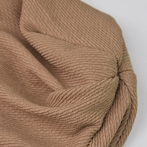 Brown knit slouchy beanie with bubble texture fabric and stylish patch detailing