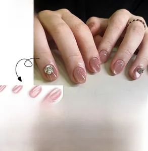 Macro detail of pink cat-eye press-on nails with sparkling rhinestones and shimmer finish