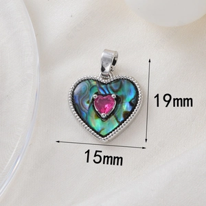Detail view of heart-shaped abalone shell pendant with pink gem and 15x19mm dimensions