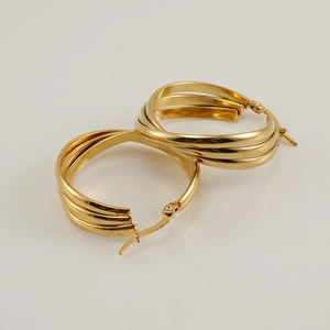 Detalle de pendientes de aro multicapa chapados en oro de 18 quilates con fondo neutro