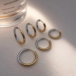 Detailed view of three pairs of two-tone gold and silver hoop earrings in various sizes