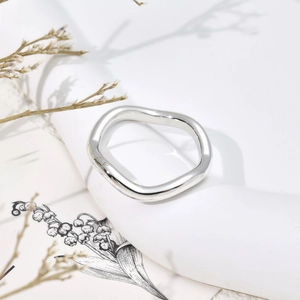 Minimalist wave-shaped stainless steel ring with polished finish on artistic base