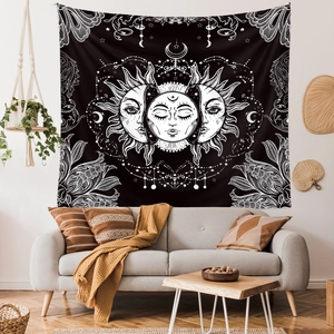 Detail of sun and moon tapestry displayed over a gray sofa in a boho living room