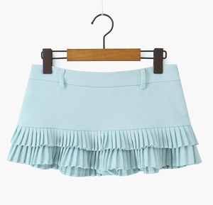 Détail d'une mini-jupe plissée bleu clair avec ourlet à double couche et tissu mélangé