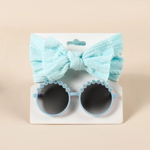 Set aus hellblauem Baby-Stirnband mit Schleife und runder Sonnenbrille mit Gänseblümchen