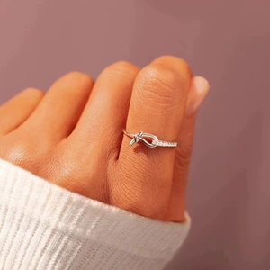 Silver knot ring with sparkling zircon pavé setting shown on model's finger