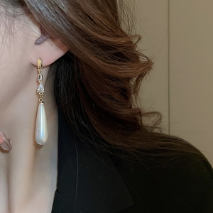 Gros plan de boucles d'oreilles pendantes dorées avec zircon et perles poires sur mannequin