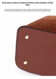Detail of red-brown leather handbag with golden protective metal feet on base