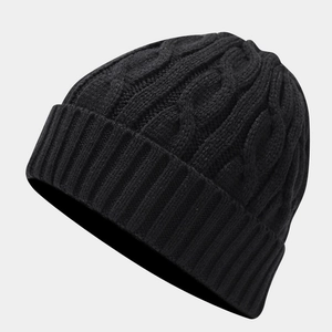 Detail of cable knit pattern and ribbed cuff on a thick black winter beanie hat